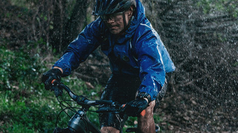 Mann fährt dynamisch mit dem Fahrrad im Regen